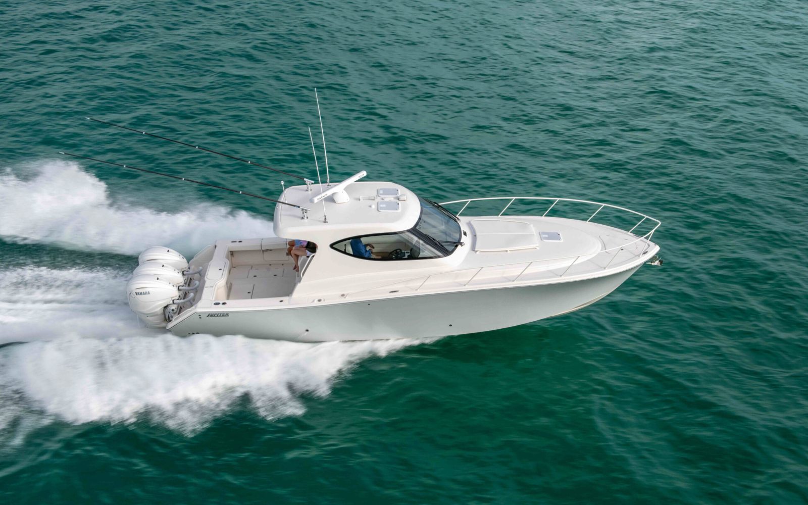 A family speeding through the open ocean in a Jupiter 41 SB.