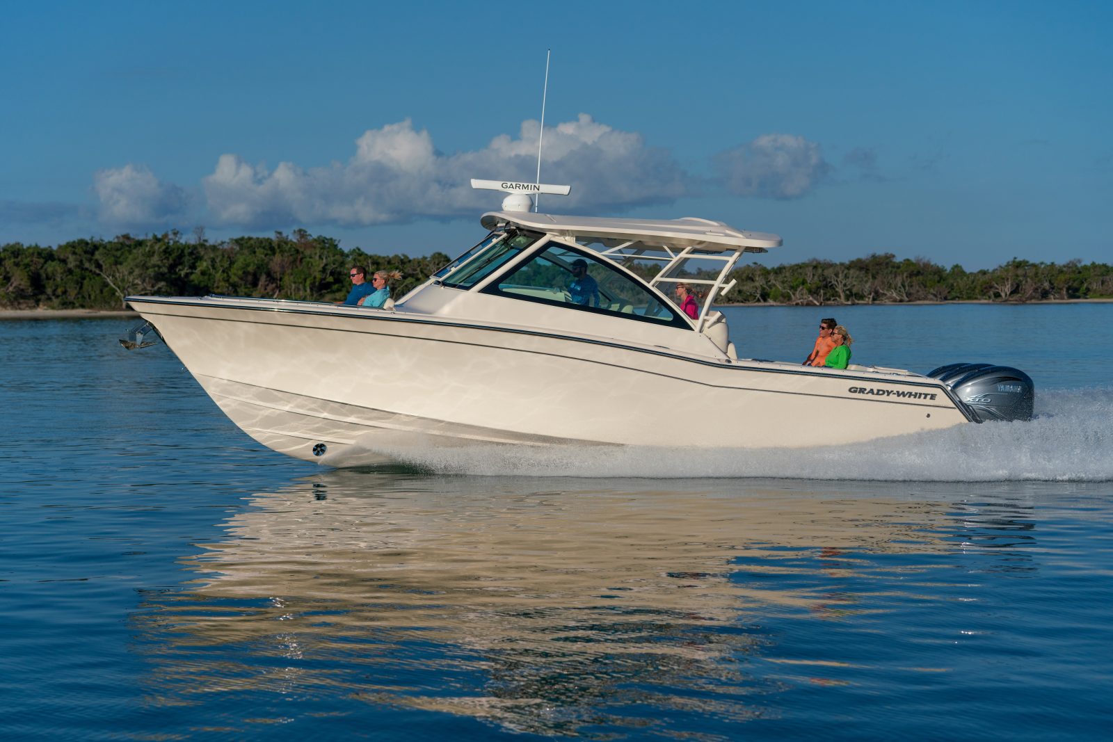 Family cruising in a Grady White 37 foot Freedom 375 on a waterway in the late afternoon.