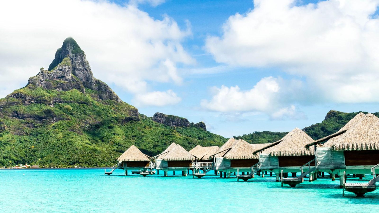 Bungalows over turquoise blue water in Tahiti